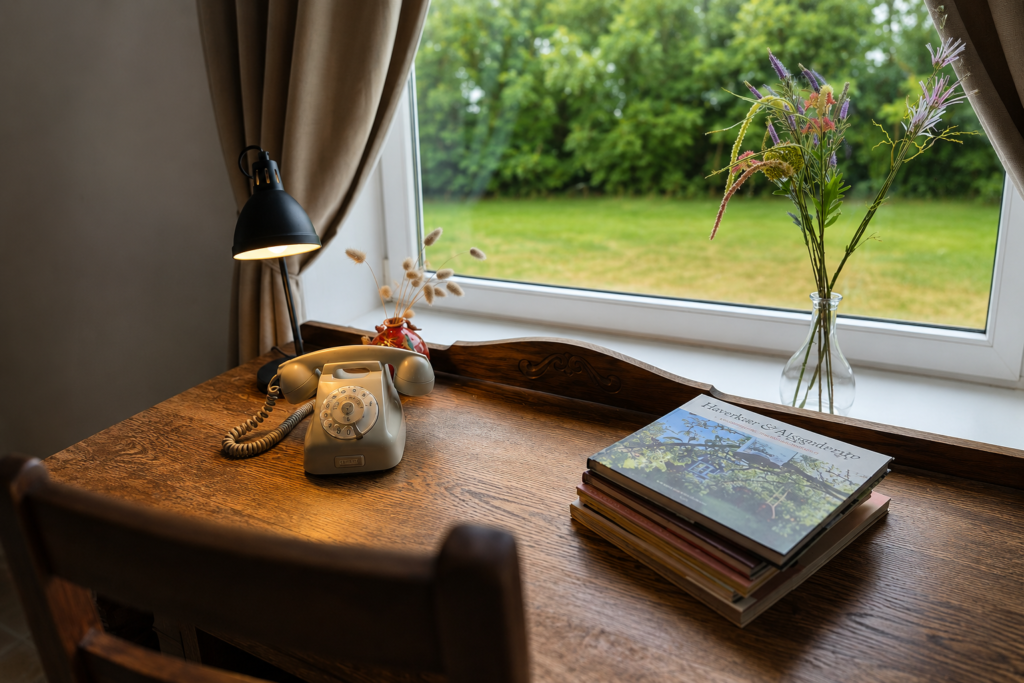 Oude draaischijftelefoon op een antiek bureau in Noldes Hygge Hjem.
